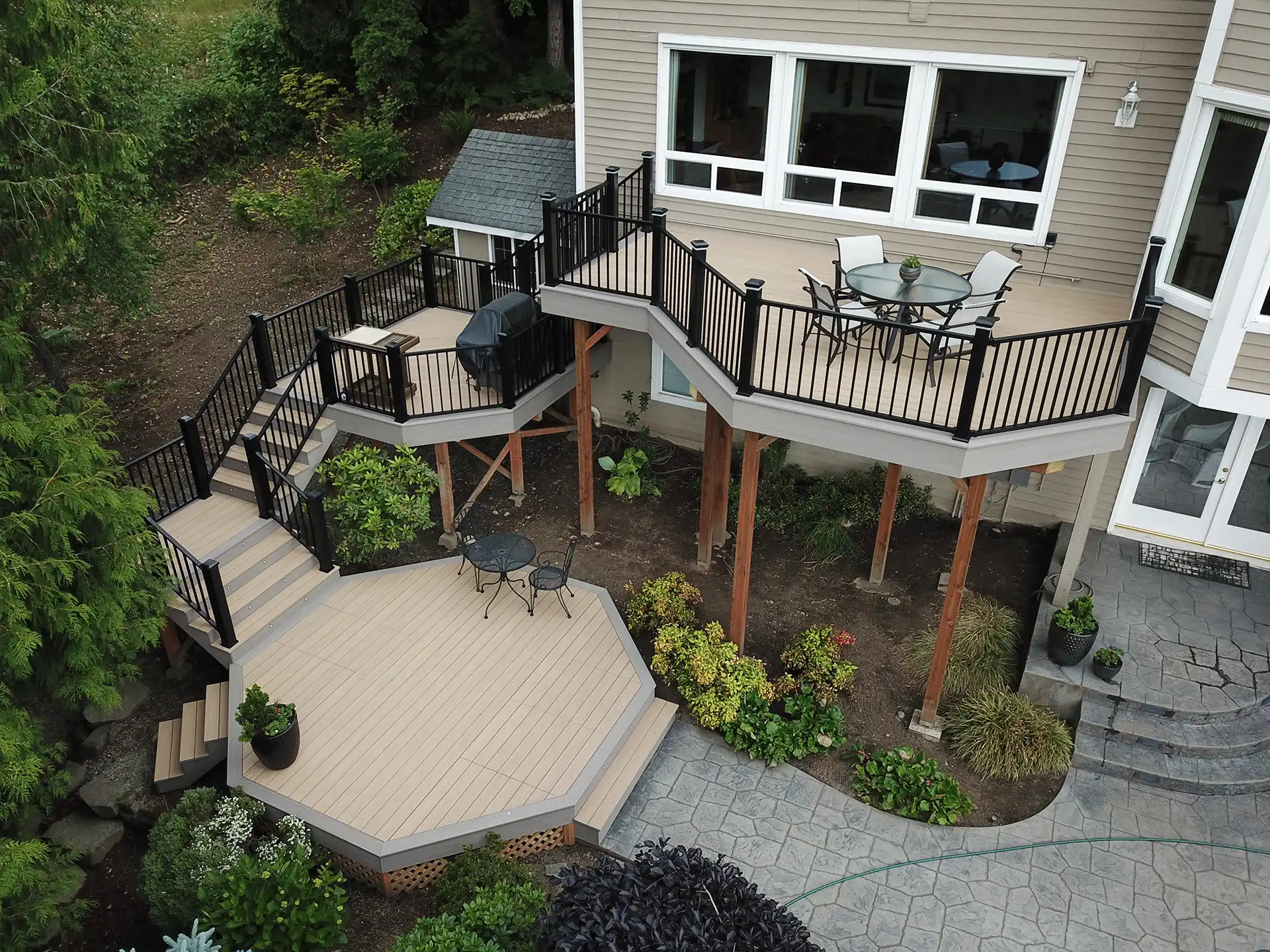 photo of a multi-level composite deck with a patio - Composite deck contractors in greater seattle area