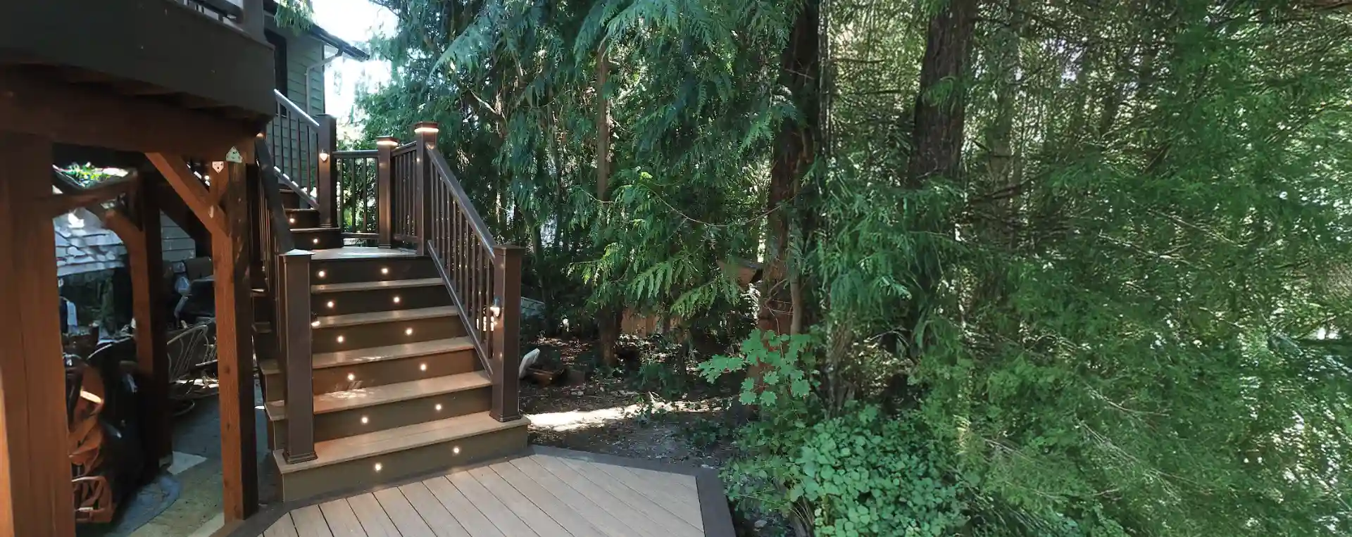 TimberTech decking with deck steps, riser lights, and lighted post caps - Deck Lighting contractors near me